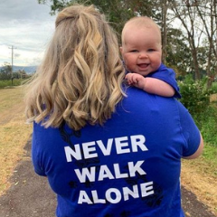 woman wearing never walk along tshirt and holding baby